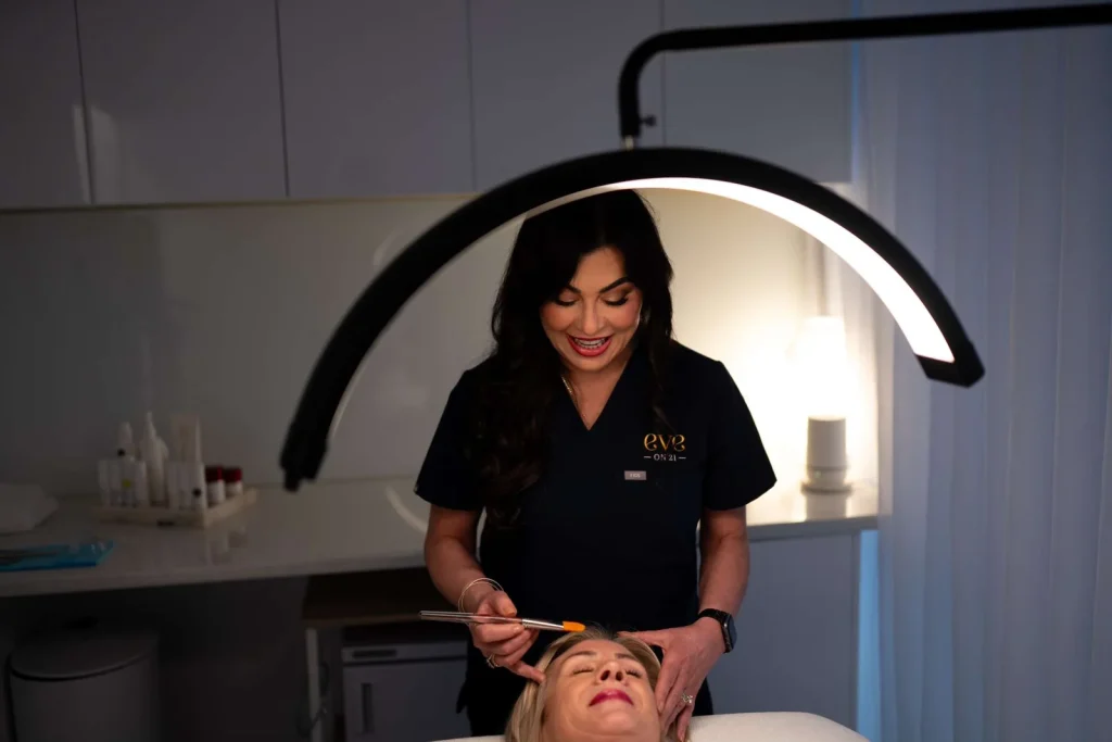 A therapist applying a facial treatment at Eve On 21