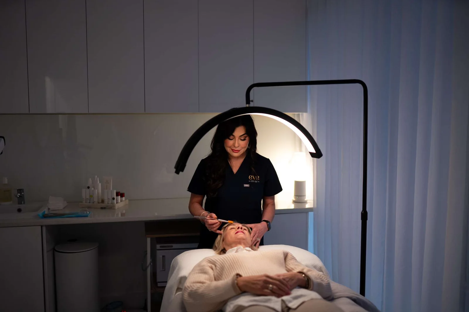 A facial treatment in a softly lit room at Eve On 21